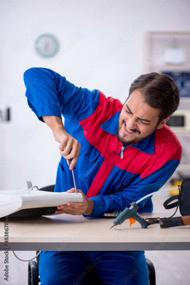 Obraz premium Young male repairman repairing heater