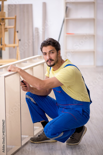 Young male carpenter working at home