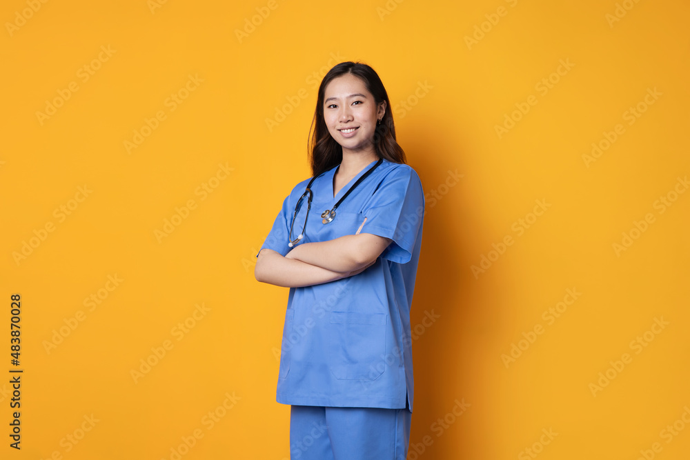 Asian doctor standing with her arms crossed smiling at the camera Asian doctor standing with her arms crossed smiling at the camera