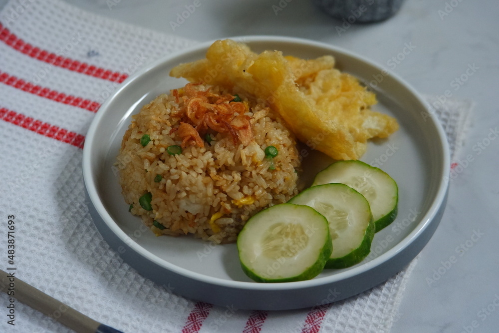 a plate of fried rice served with cucumber slices and fried egg a plate of fried rice served with cucumber slices and fried egg