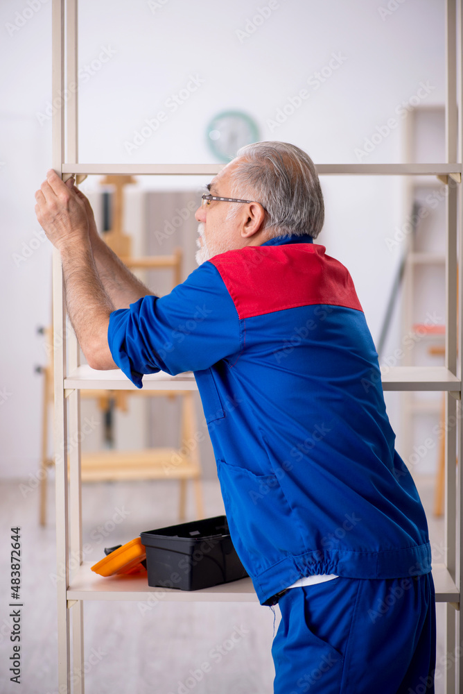 Old male carpenter working indoors Old male carpenter working indoors