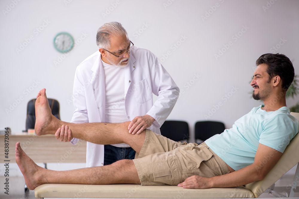 Obraz premium Young male patient visiting old male doctor