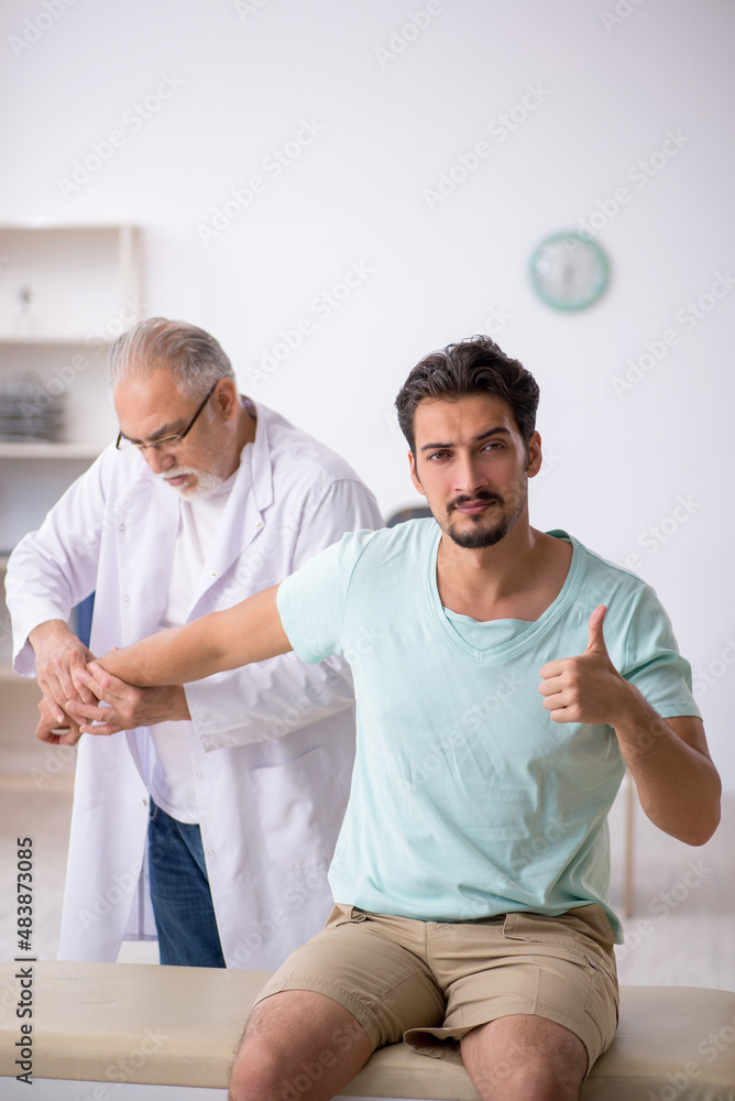 Fototapeta premium Young male patient visiting old male doctor