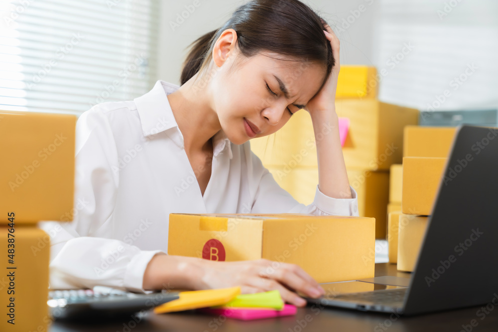 Small business, asian woman headache because there is a problem in management, delivery with packaging. Small business, asian woman headache because there is a problem in management, delivery with packaging.