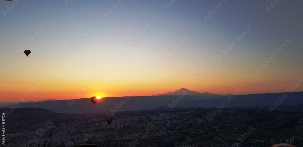 Fototapeta premium sunrise in the mountains under air ballons