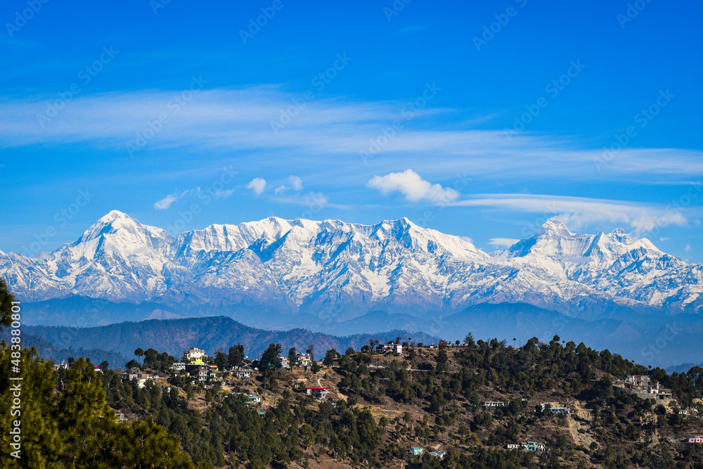 Clouds over the snow capped mountain range, beautiful Village at Uttarakhand, India