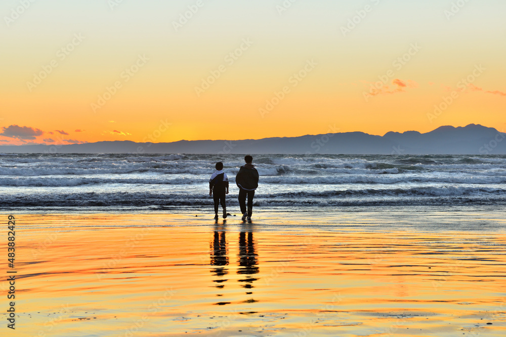 Fototapeta premium 片瀬西浜海岸の夕陽と波打ち際で遊ぶ子供たち