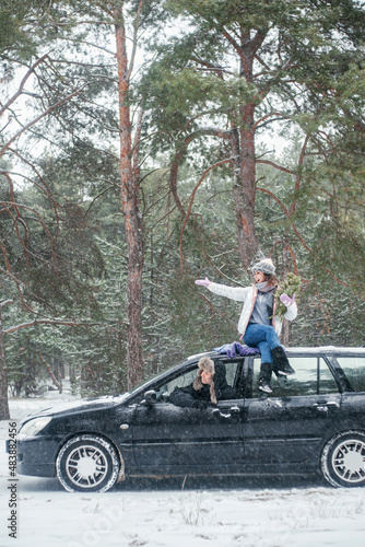 Man and woman travel by car in winter forest