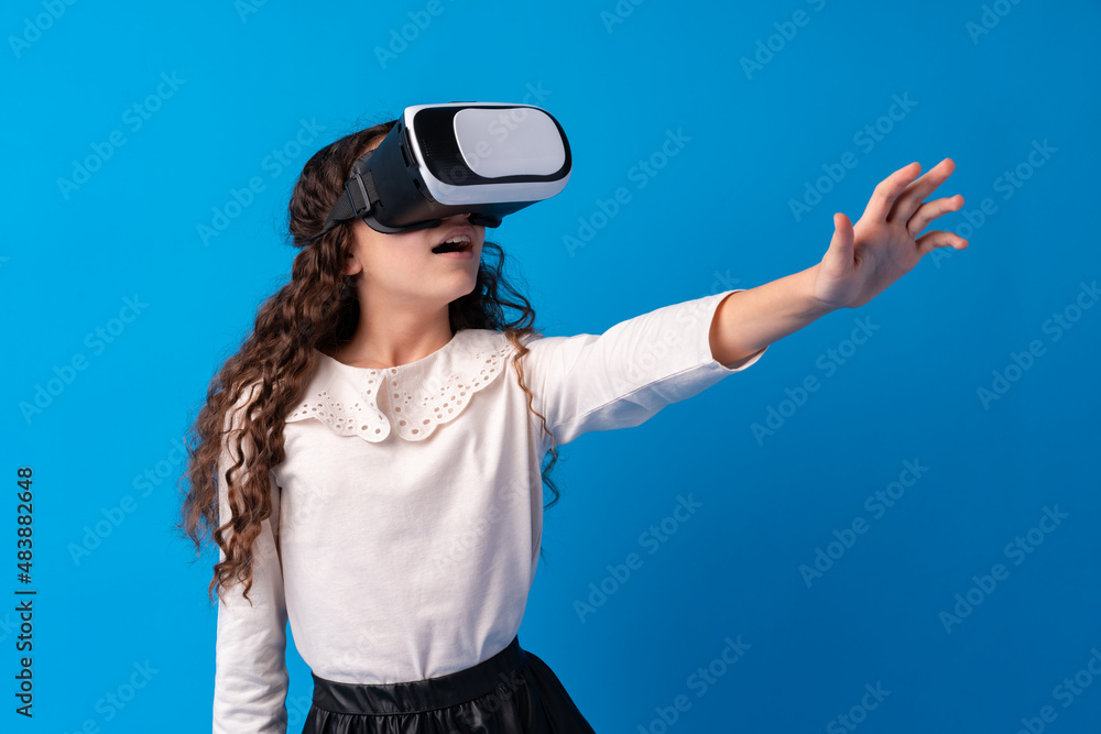 Girl with virtual reality glasses on blue background. Girl with virtual reality glasses on blue background.