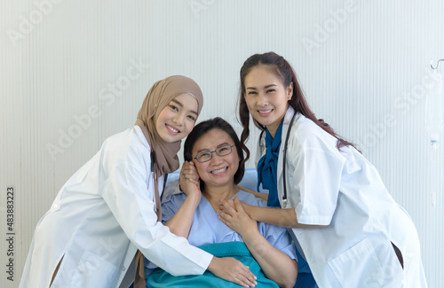 Group photo of muslim doctor, female doctor and elderly patient in hospital room. smiling and looking at camera. takes care and cheerful concept.