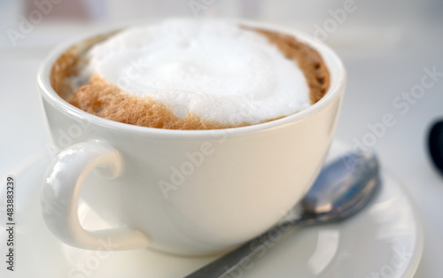 Close-up white frothed milk on cappuccino or latte coffee. Hot coffee ready-to-drink in the morning.