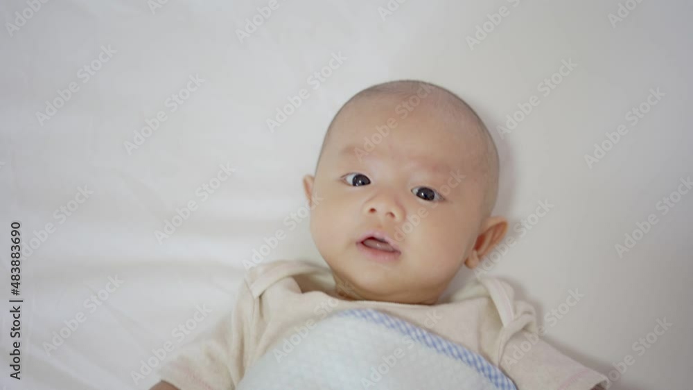 Adorable, Asian newborn lying on bed. Baby boy looking camera and smile happy face. Little innocent new infant child in first day of life. Mother day concept. Adorable, Asian newborn lying on bed. Baby boy looking camera and smile happy face. Little innocent new infant child in first day of life. Mother day concept.