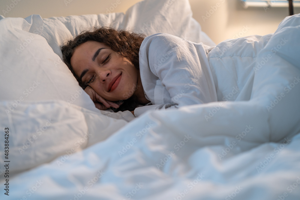 Latino beautiful woman lying down on bed in bedroom in dark night room Latino beautiful woman lying down on bed in bedroom in dark night room