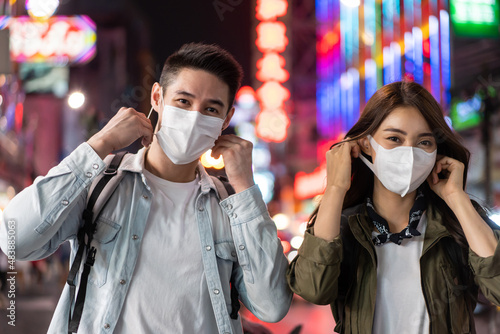 Asian young couple remove mask while travel in city for honeymoon trip