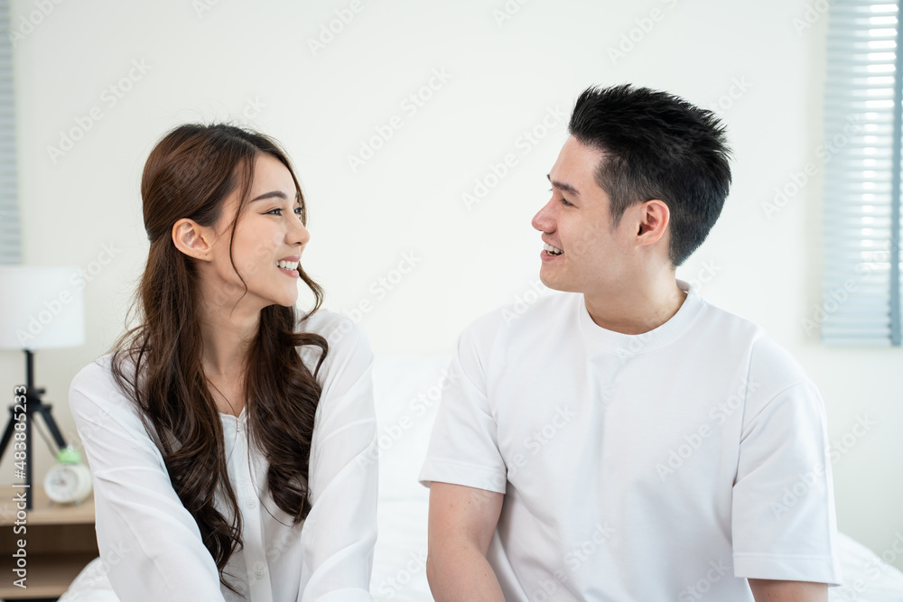Portrait of Asian new marriage couple sit on bed and look each other. Portrait of Asian new marriage couple sit on bed and look each other.
