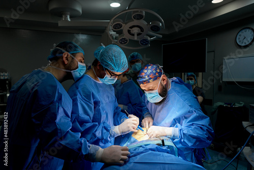 doctors in the operating room perform surgery on a patient photo