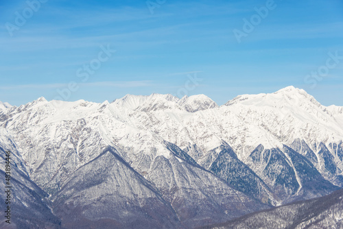 Mountain snowy landscape, mountain range pass blue sky.