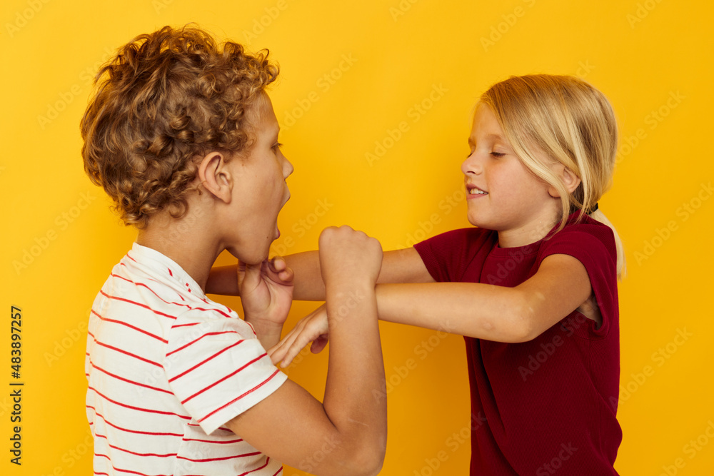 Cute preschool kids cuddling fashion childhood entertainment yellow background Cute preschool kids cuddling fashion childhood entertainment yellow background