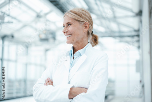 Happy scientist with arms crossed in industry photo