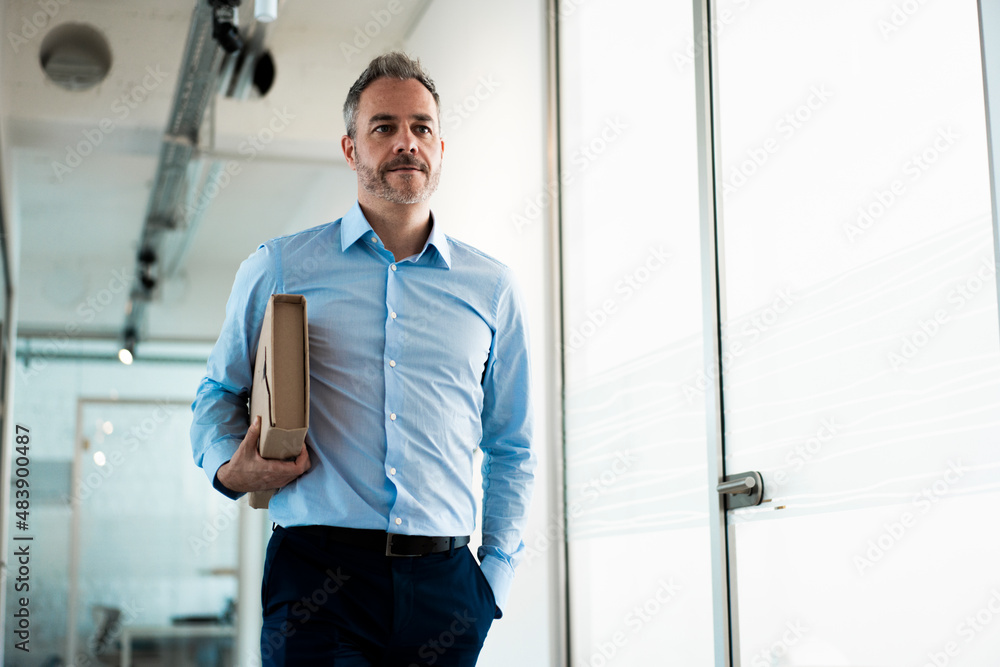 Confident working man carrying file folder walking in office corridor Confident working man carrying file folder walking in office corridor