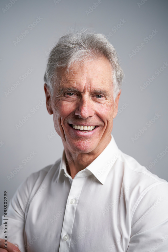 Smiling businessman against gray background Smiling businessman against gray background