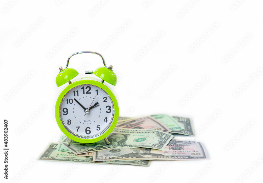 Green alarm clock and pile of dollar bills on isolate white background. Green alarm clock and pile of dollar bills on isolate white background.