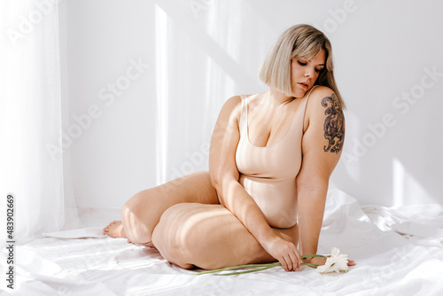 Young curvy blond woman with flowers photo