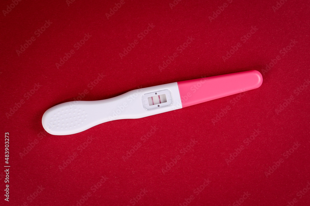 Positive pregnancy test on a red background Positive pregnancy test on a red background