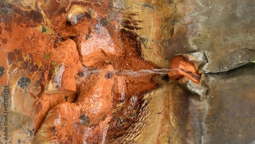 Iron mineral water spring spouting out of stone. Tesikov Czech Republic