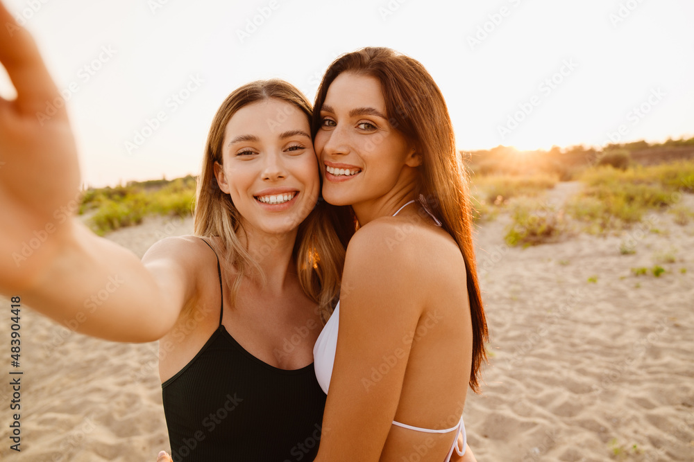 Young white women smiling together while taking selfie photo