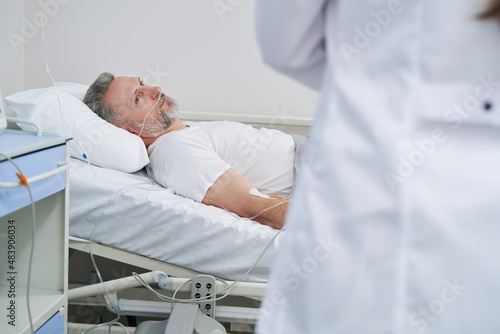 Recumbent patient staring at attending doctor during ward round