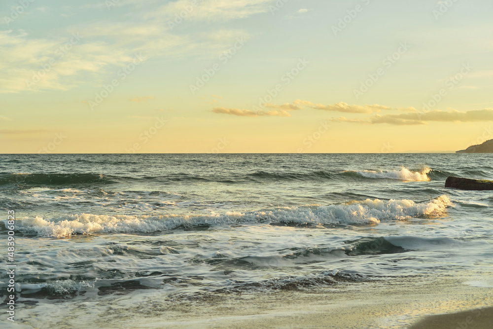 Fototapeta premium Seascape at sunset. Golden sunrise on the sandy beach.