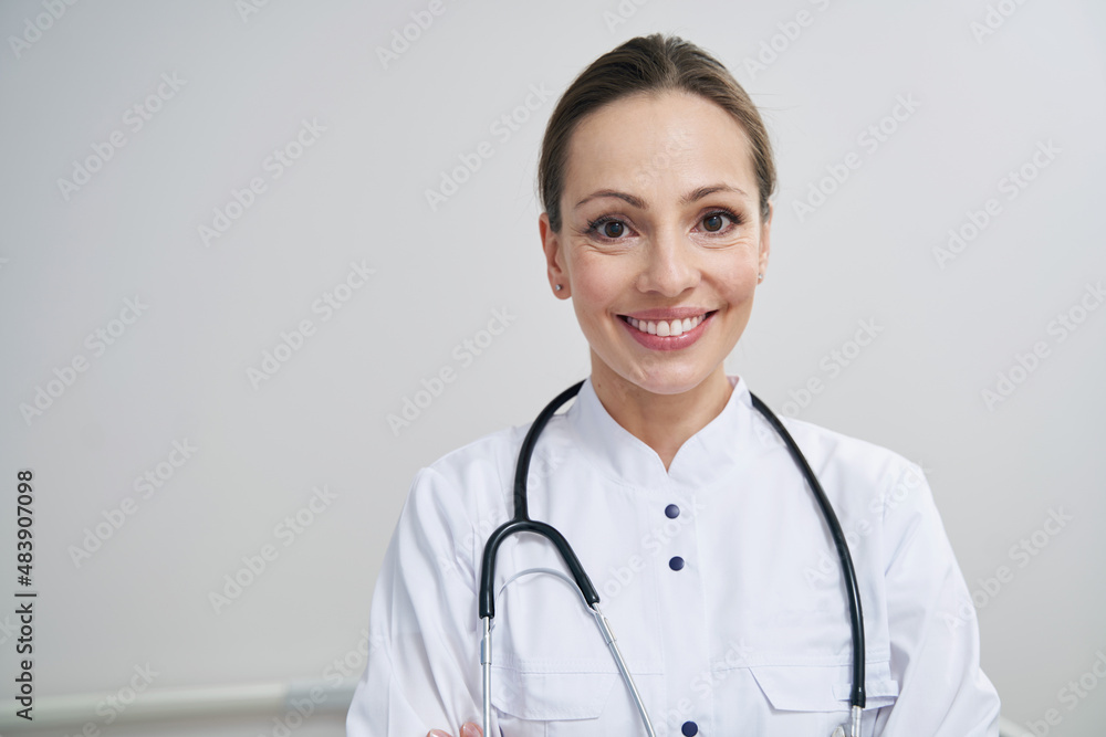 Joyous young doctor posing for camera in workplace Joyous young doctor posing for camera in workplace
