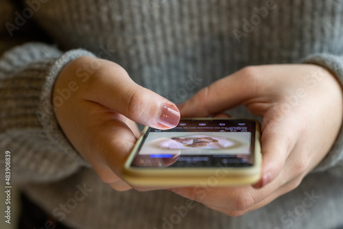 Close up of a young woman with smartphone, happy girl using mobile phone standing up. Concept of online addiction, social media, sms messages, sex dating, internet. High quality photo