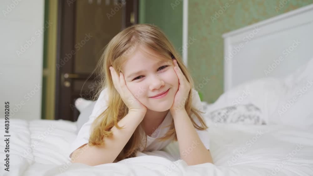 a cute little girl lies in bed at home. a cute little girl lies in bed at home.