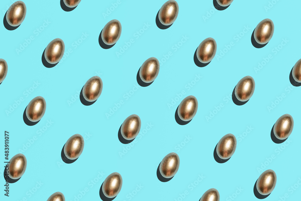 Golden eggs pattern against bright blue background. Creative Easter layout. Golden eggs pattern against bright blue background. Creative Easter layout.