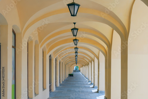 Valokuvatapetti Arched colonnade with hanging lanterns. Perspective. Summer. Day