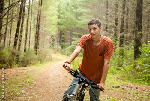 happy teen boy riding a bike on natural background, forest or park. healthy lifestyle, family day out