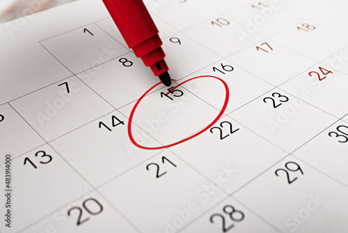 Calendar page with red pen close up. Focus on number 15 in calendar and empty red circle for design in your ideas and work concept