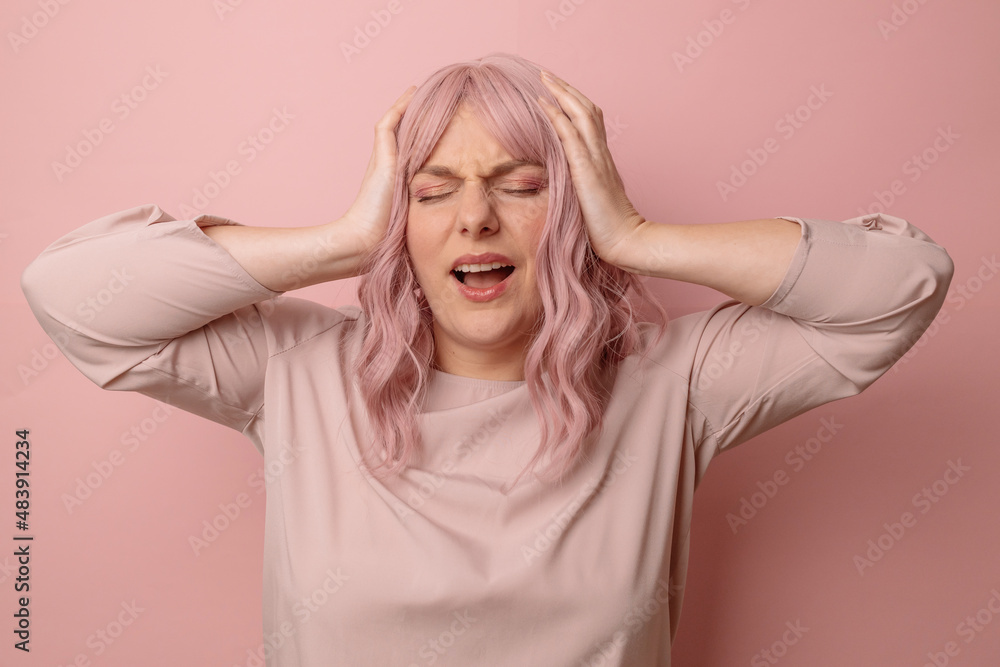 Young pink hair 30s woman standing with hand on head for pain in head because stress over pink background. Suffering migraine. Young pink hair 30s woman standing with hand on head for pain in head because stress over pink background. Suffering migraine.