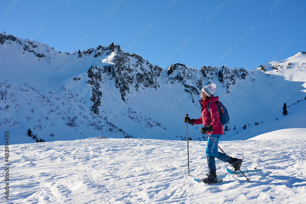  nice senior woman snowshoeing in the snowy landscape of Kleinwalsertal in Vorarlberg, Austria