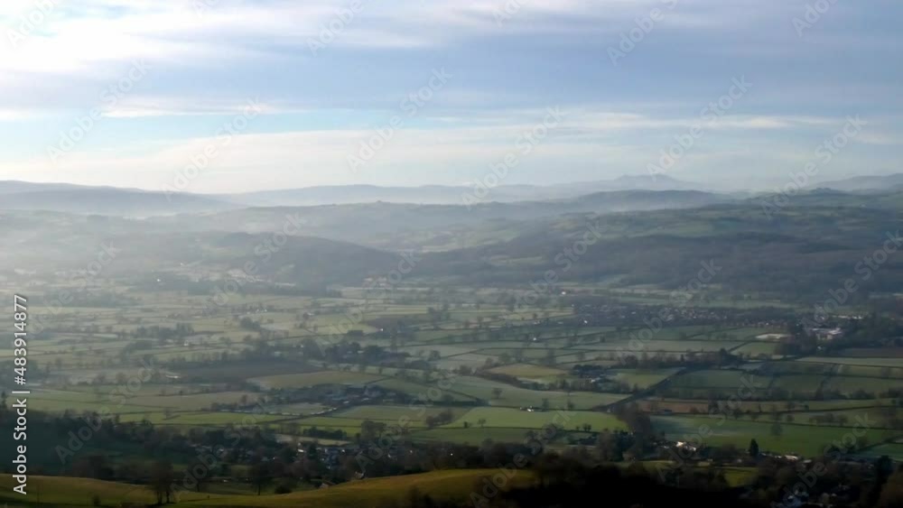 Distant misty layers of panoramic rural mountain valley countryside at sunrise static shot Distant misty layers of panoramic rural mountain valley countryside at sunrise static shot