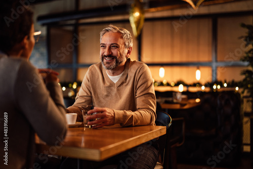 Smiling caucasian adult man  having a drink with his female partner  at a restaurant.