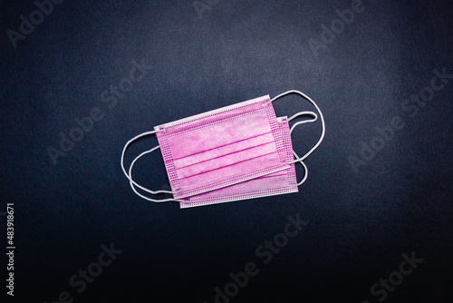 Two pink face masks in the center on black background, empty space