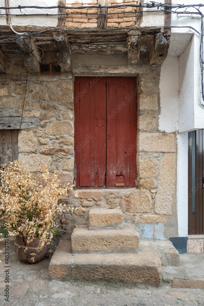 An old red painted wooden door with a cat flap An old red painted wooden door with a cat flap