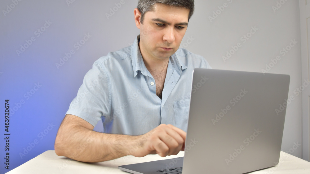 A man is typing on a laptop standing on a table A man is typing on a laptop standing on a table