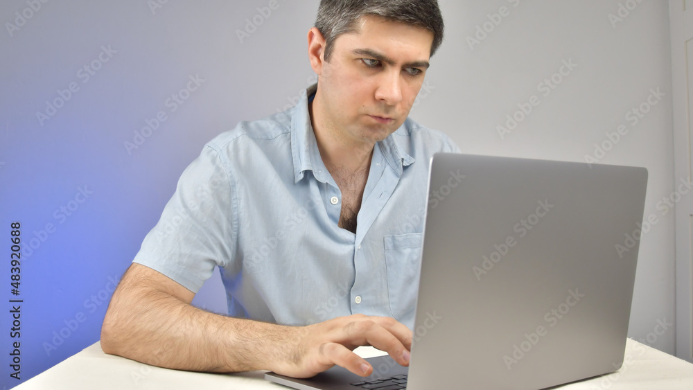 A man is typing on a laptop standing on a table A man is typing on a laptop standing on a table