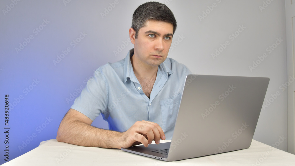 A man is typing on a laptop standing on a table A man is typing on a laptop standing on a table