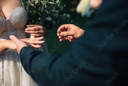 close-up of the groom puts the wedding ring on the finger of the bride at the ceremony