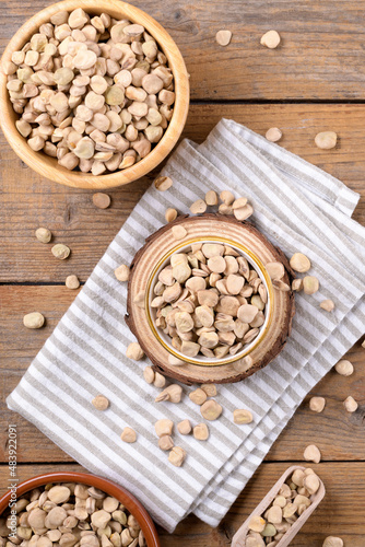 Cicerchia or indian pea on a bowls with napkin on natural wooden background, gluten free food. Legumes known as Lathyrus Sativus, Chickling Vetch, Blue Sweet Pea made in Puglia, top view, flat lay